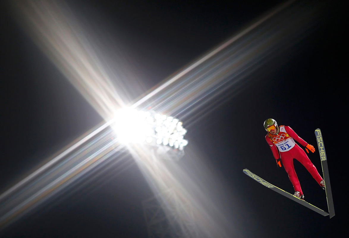 Польский спортсмен Камиль Стох парит в воздухе на квалификационном раунде в прыжках на лыжах с трамплина. Днём позже он возмёт золотую медаль. 8 февраля 2014 года. (Фото REUTERS/Kai Pfaffenbach)